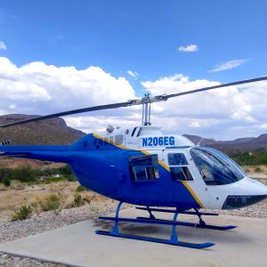 Blue and White Helicopter sitting on the Helipad at Wild West Helicopters
