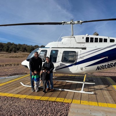 a group of people standing next to a helicopter